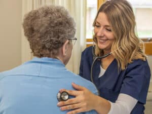 nurse checking the heartbeat of an elderly resident