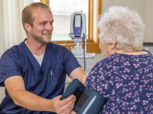 nurse taking the blood pressure of an elderly resident