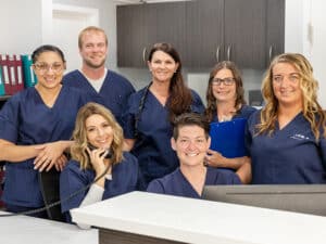 smiling nurses gathered behind the nurse's station desk