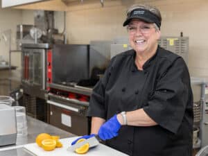chef slicing oranges and smiling