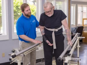 physical therapist assisting elderly resident during physical therapy exercise